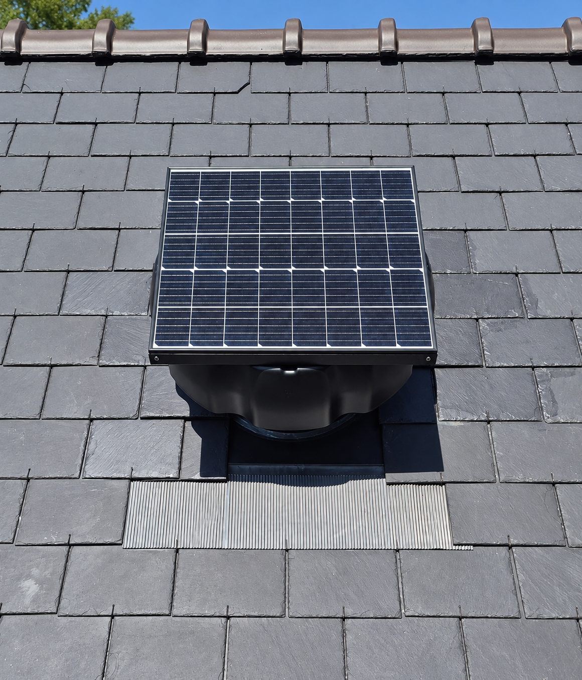 Extracteur solaire de toiture posé sur une couverture en ardoise